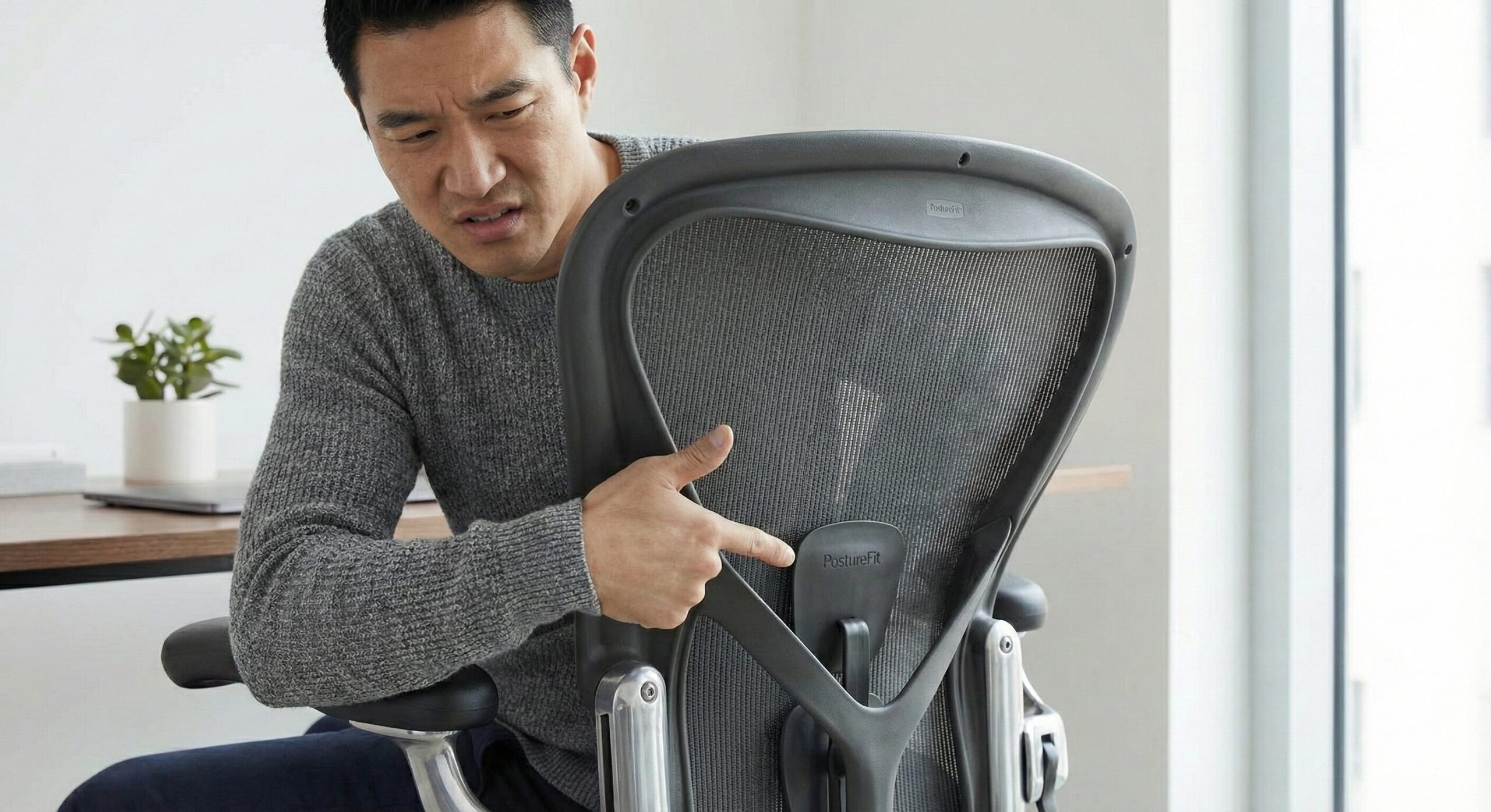 アーロンチェアの背面パーツを細かくチェックする手元